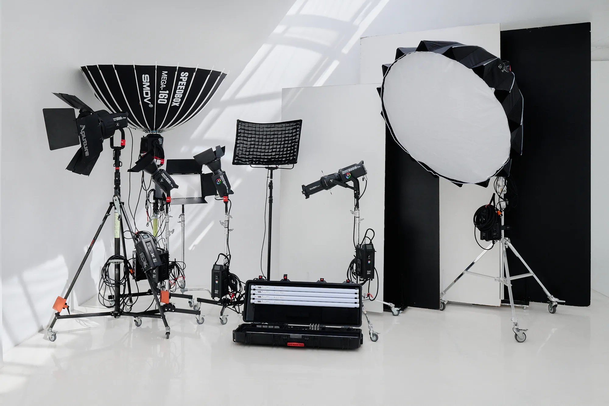 Aufgereihtes Licht- und Filmequipment im Studio — Softboxen, LED-Panels, Stative