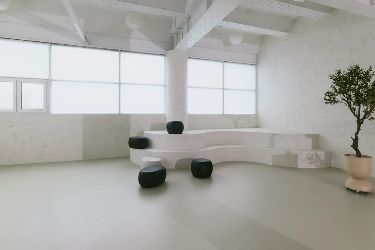 Gaia Studio — minimalistisches Tageslichtstudio in warmen Beigetönen mit Rundbögen in Neuss