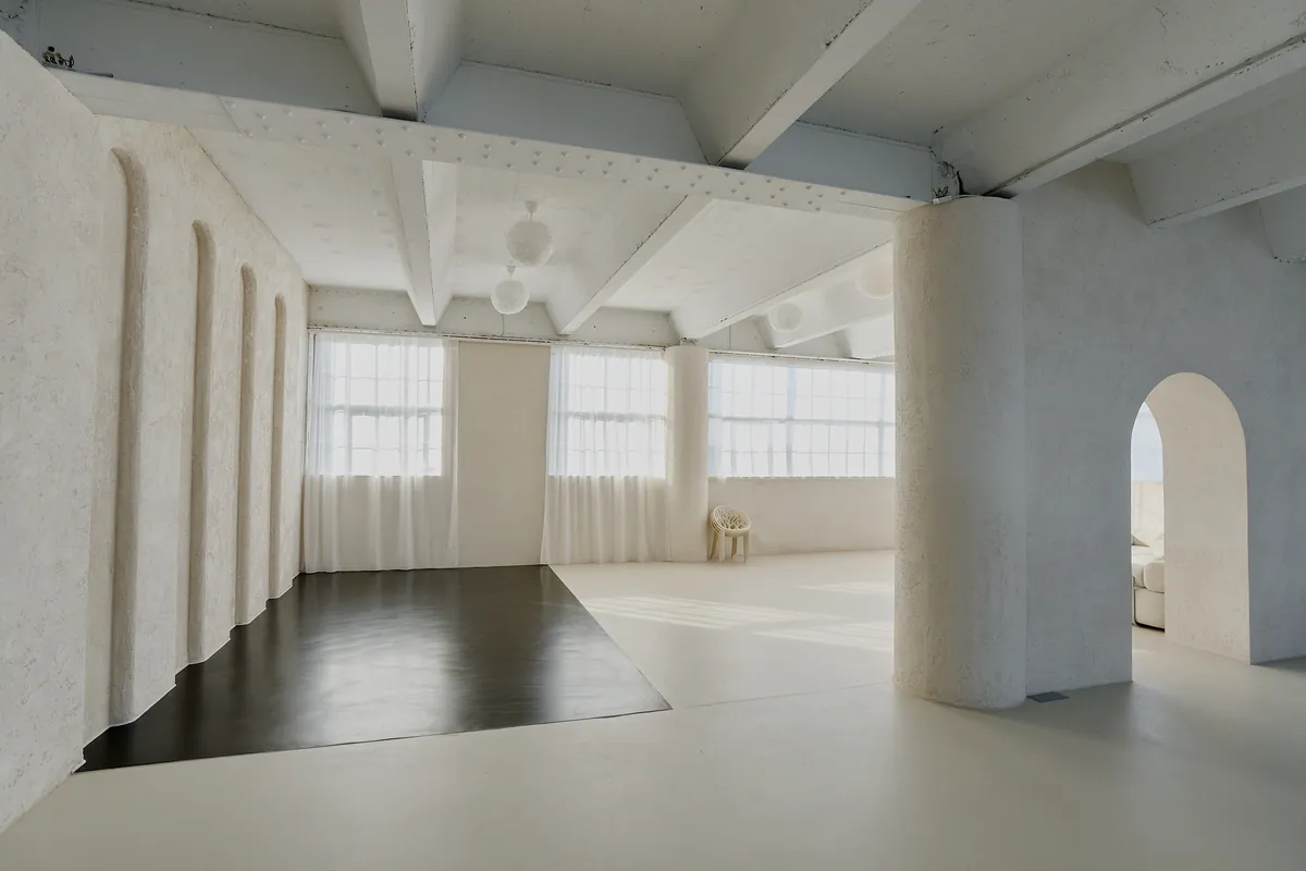 Gaia Studio — Rundbögen, Vorhänge und schwarzer Designboden